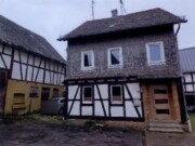 Einfamilienhaus mit Nebengebäuden und unbebauten Grundstücksflächen